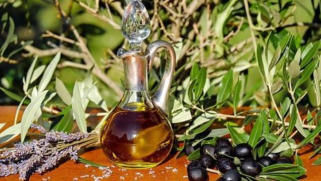 Olive oil, oilves, and lavender on wooden board
